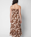 Woman wearing a floral patterned dress on a plain background