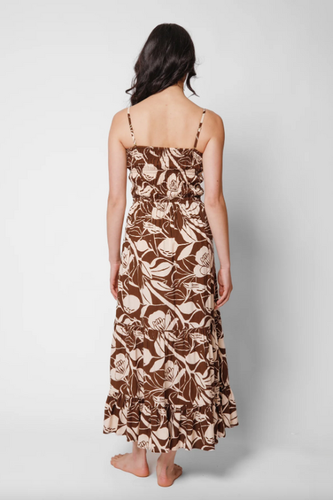 Woman wearing a floral patterned dress on a plain background