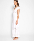 Woman wearing a white dress against a plain background