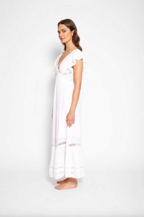 Woman wearing a white dress against a plain background