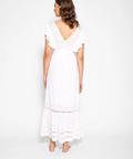 Woman wearing a white dress against a plain background