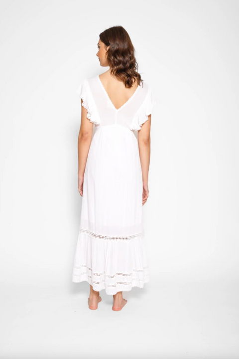 Woman wearing a white dress against a plain background