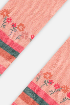 A close-up of a pink knit textile strip with a floral pattern and horizontal striped bands, shown diagonally on a light gray background.