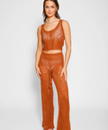 Woman wearing a brown crochet outfit on a white background