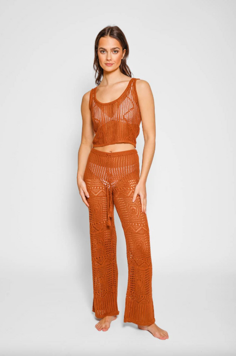 Woman wearing a brown crochet outfit on a white background