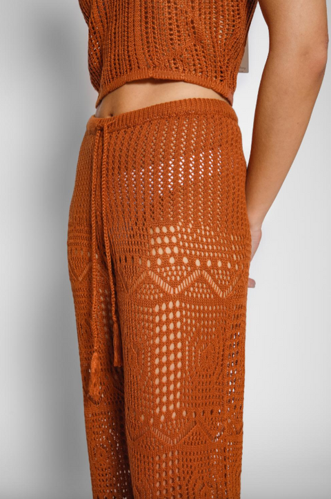 Brown crochet top and pants on a neutral background