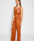 Woman wearing a brown crochet outfit on a white background