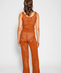Person wearing a rust-colored crochet outfit on a white background