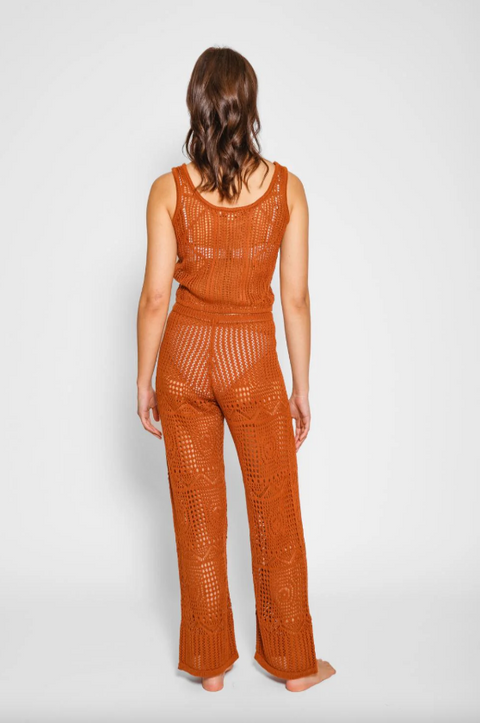 Person wearing a rust-colored crochet outfit on a white background