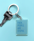 This image features a clear acrylic keychain with a bold, printed message. The keychain displays the phrase "FUCK.