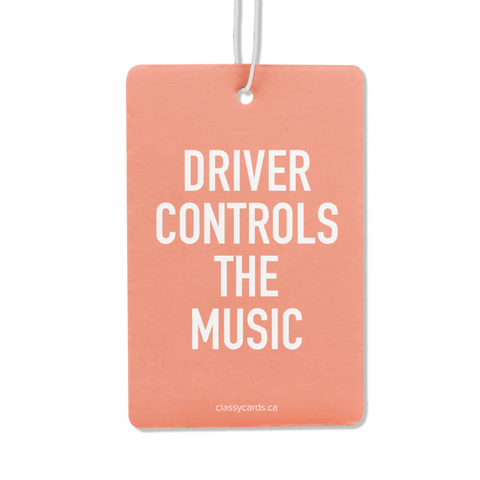 A pink double-sided air freshener with the text 'DRIVER CONTROLS THE MUSIC' printed in black. It comes with a white nylon hanging cord.