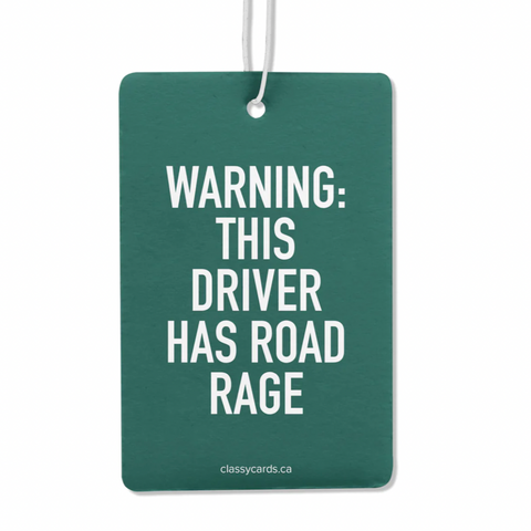 A green double-sided air freshener with the text 'WARNING: THIS DRIVER HAS ROAD RAGE' printed on the front side, attached to a nylon hanging cord.
