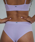Person wearing a light purple bikini set with a plain background