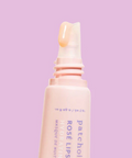 Lip mask bottle with a pink cap on a light purple background
