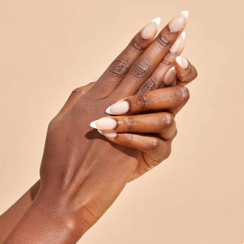 Close-up of a hand with beige nail polish on a beige background