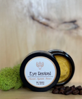 Eye Revival product with a green sponge and coffee beans on a wooden surface