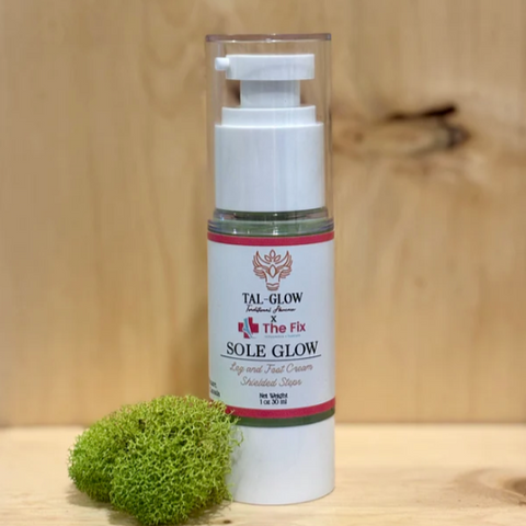 Skincare bottle labeled 'Sole Glow' on a wooden surface with green moss.