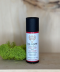 Lip balm container with 'Tal-Glow' branding on a wooden surface with a blurred natural background