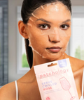 Woman applying a face mask with a 'patchology' product in the foreground