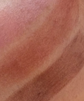 Close-up of a skin swatch with brown and beige tones.
