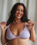 Woman wearing a light purple bikini against a neutral background