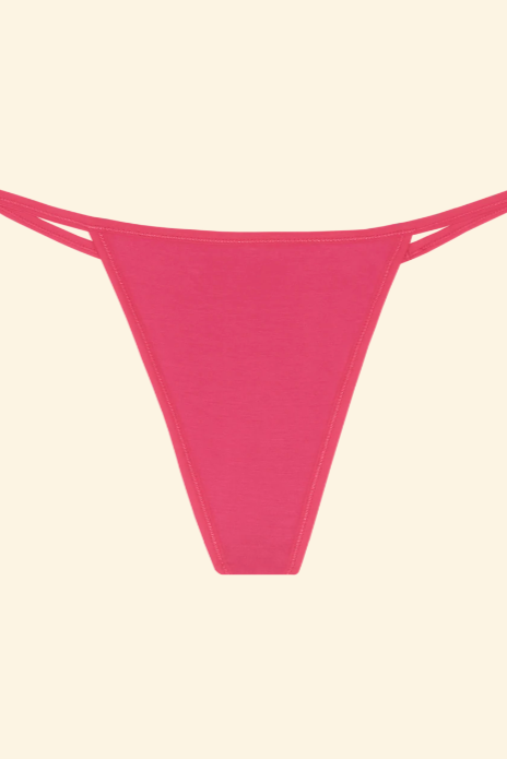 Pink thong bikini bottom on a beige background