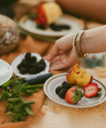 Person at a picnic table with food and a blurred background
