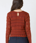 Person wearing a red lace top and denim skirt on a white background