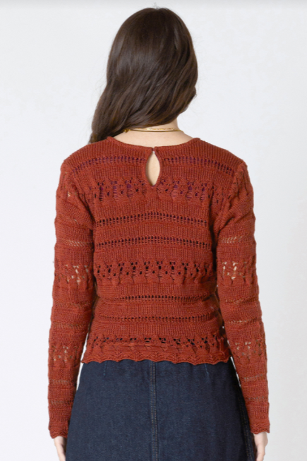 Person wearing a red lace top and denim skirt on a white background