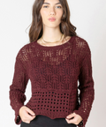 Woman wearing a burgundy knitted sweater and black skirt on a white background