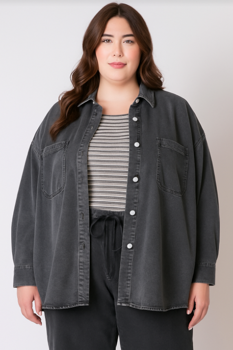 Woman wearing a dark denim jacket over a striped shirt on a plain background