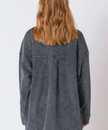 Person wearing a gray oversized jacket on a white background