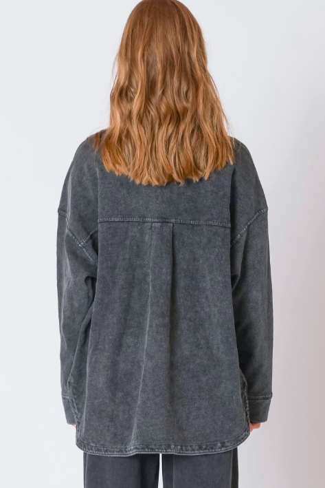 Person wearing a gray oversized jacket on a white background
