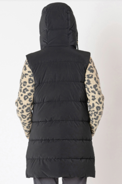 Black puffer vest worn over a leopard print jacket on a plain background