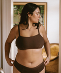 Woman wearing a brown bikini set indoors with a neutral background