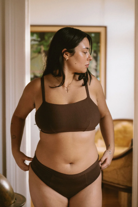 Woman wearing a brown bikini set indoors with a neutral background