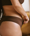 Person wearing brown underwear in a neutral setting