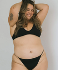 Woman wearing a black bikini against a plain background