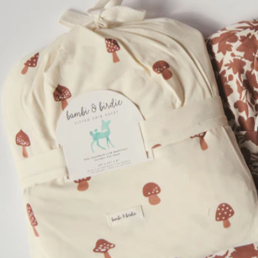 Two crib sheets with tags on a website page, featuring 'bambi & birdie' brand.