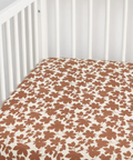 Floral-patterned crib sheet on a white crib