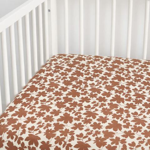 Floral-patterned crib sheet on a white crib