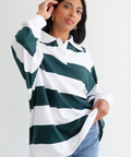 Woman wearing a green and white striped shirt with a plain background