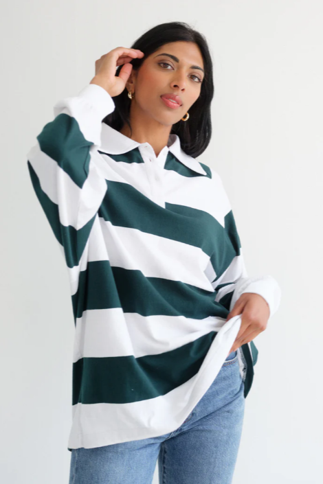 Woman wearing a green and white striped shirt with a plain background