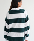Person wearing a green and white striped sweater on a plain background