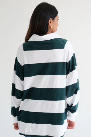 Person wearing a green and white striped sweater on a plain background