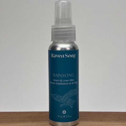 Raven Song Rainsong room & linen mist bottle on a wooden surface with a gray background