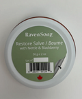 Container of 'Raven Song Restore Salve' with green label on a white background