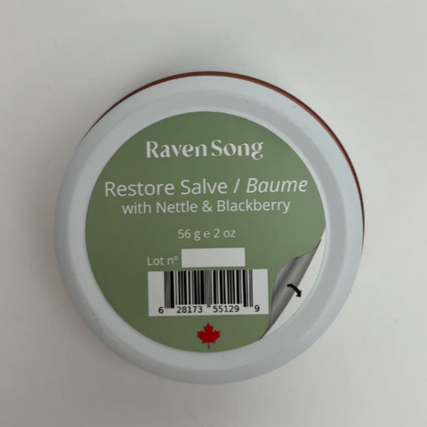 Container of 'Raven Song Restore Salve' with green label on a white background
