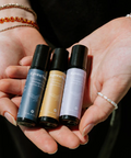 Hands holding three small bottles with a product page layout in the background