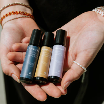 Hands holding three small bottles with a product page layout in the background